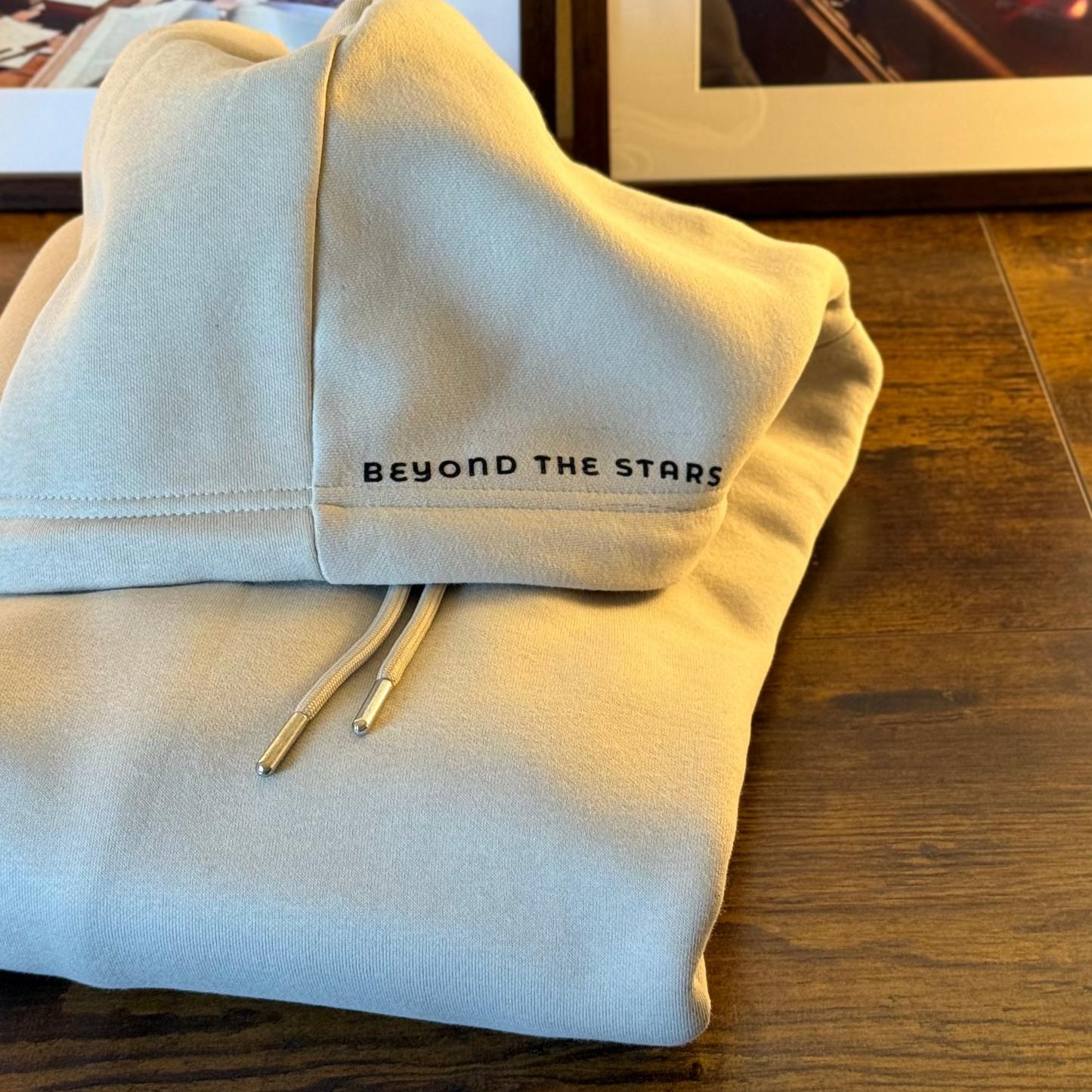 Close-up of beige minimalist streetwear hoodie with Urdu poetry sleeve print, engineered for permanence.